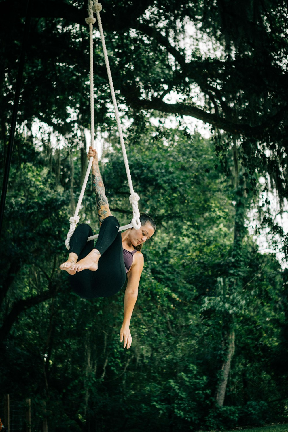 a woman hanging upside down on a rope