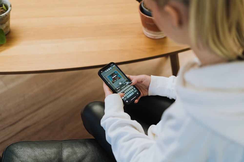 a woman sitting in a chair looking at her cell phone