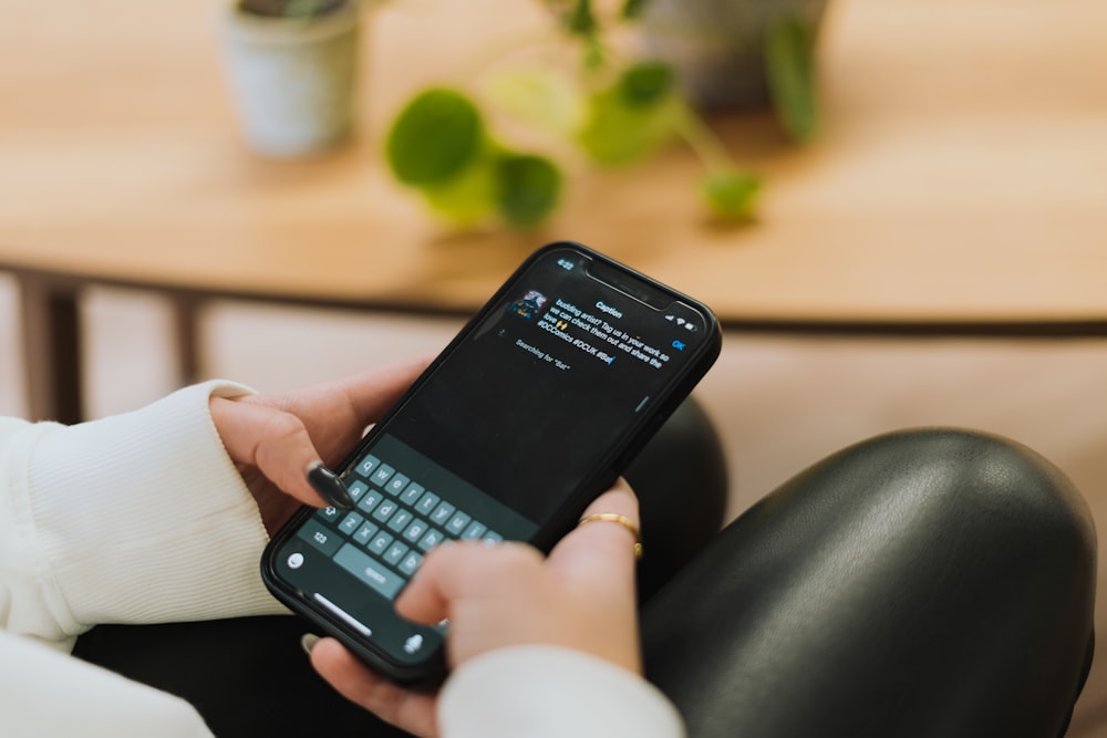 a person sitting on a couch holding a cell phone