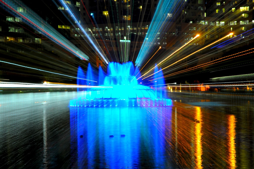 a blue fountain with lights reflecting in the water