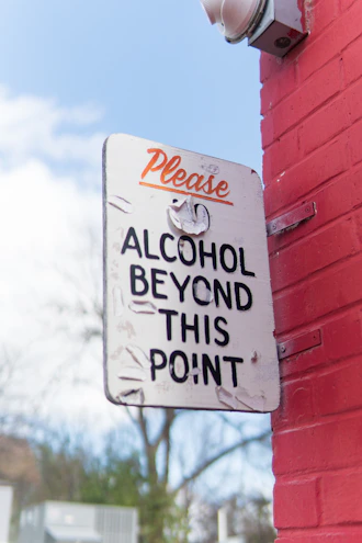 a sign on a red brick wall that says please alcohol beyond this point