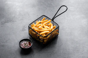Golden, crispy fries served in a rustic basket with a side of tangy ketchup.