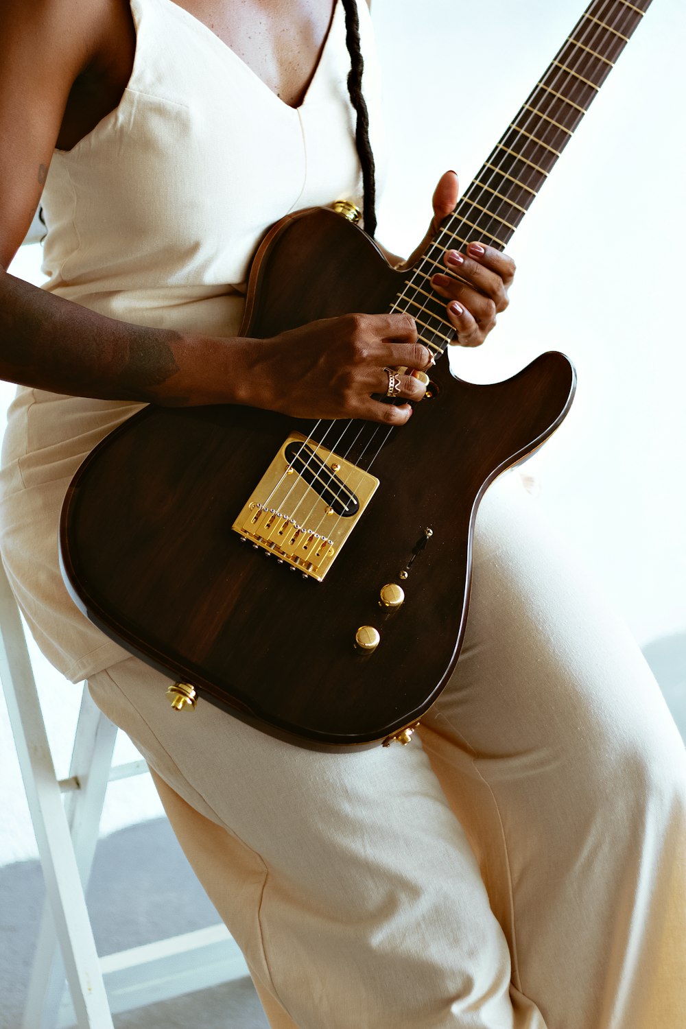 a woman sitting on a chair holding a guitar