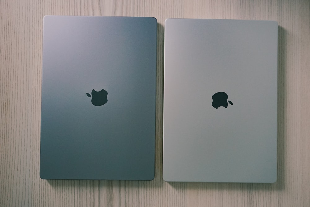 two silver ipads side by side on a wooden surface