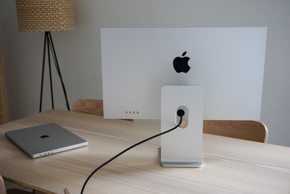 an apple computer sitting on top of a wooden desk