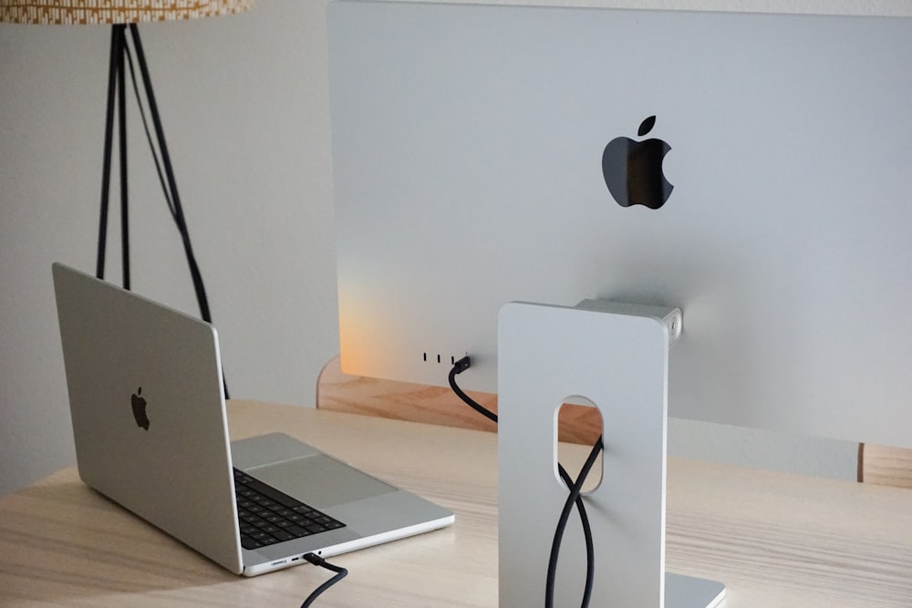 an apple laptop computer sitting on top of a wooden desk