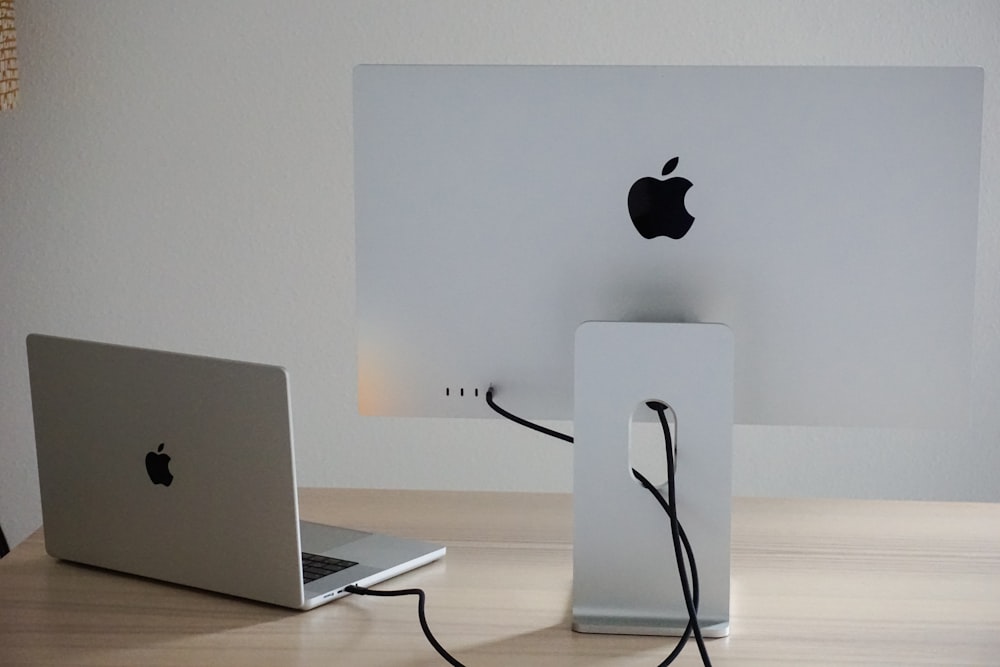 an apple computer and a laptop on a table