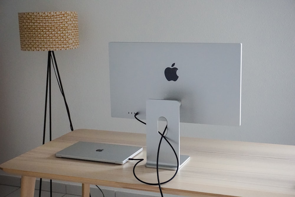 an apple computer sitting on top of a wooden desk