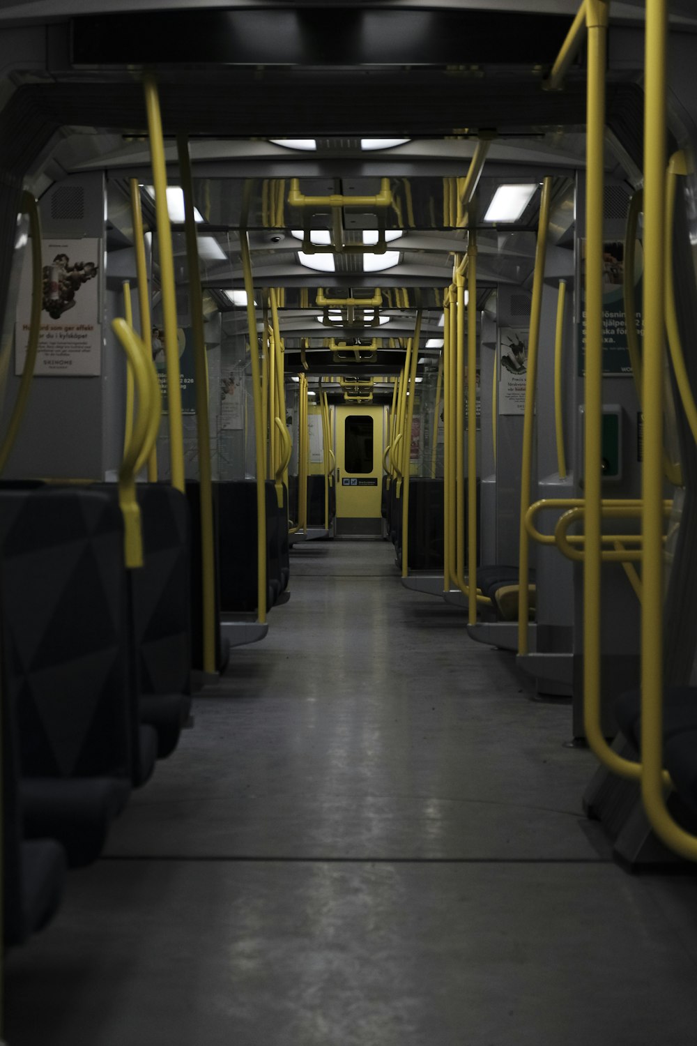 a subway car with yellow railings and seats