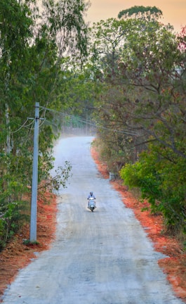 a person riding a motorcycle down a dirt road