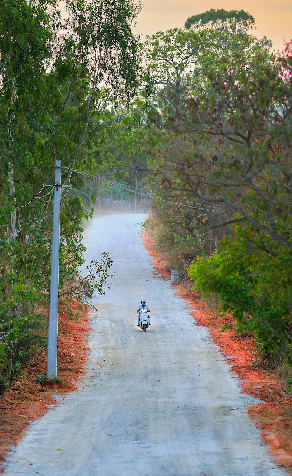 a person riding a motorcycle down a dirt road