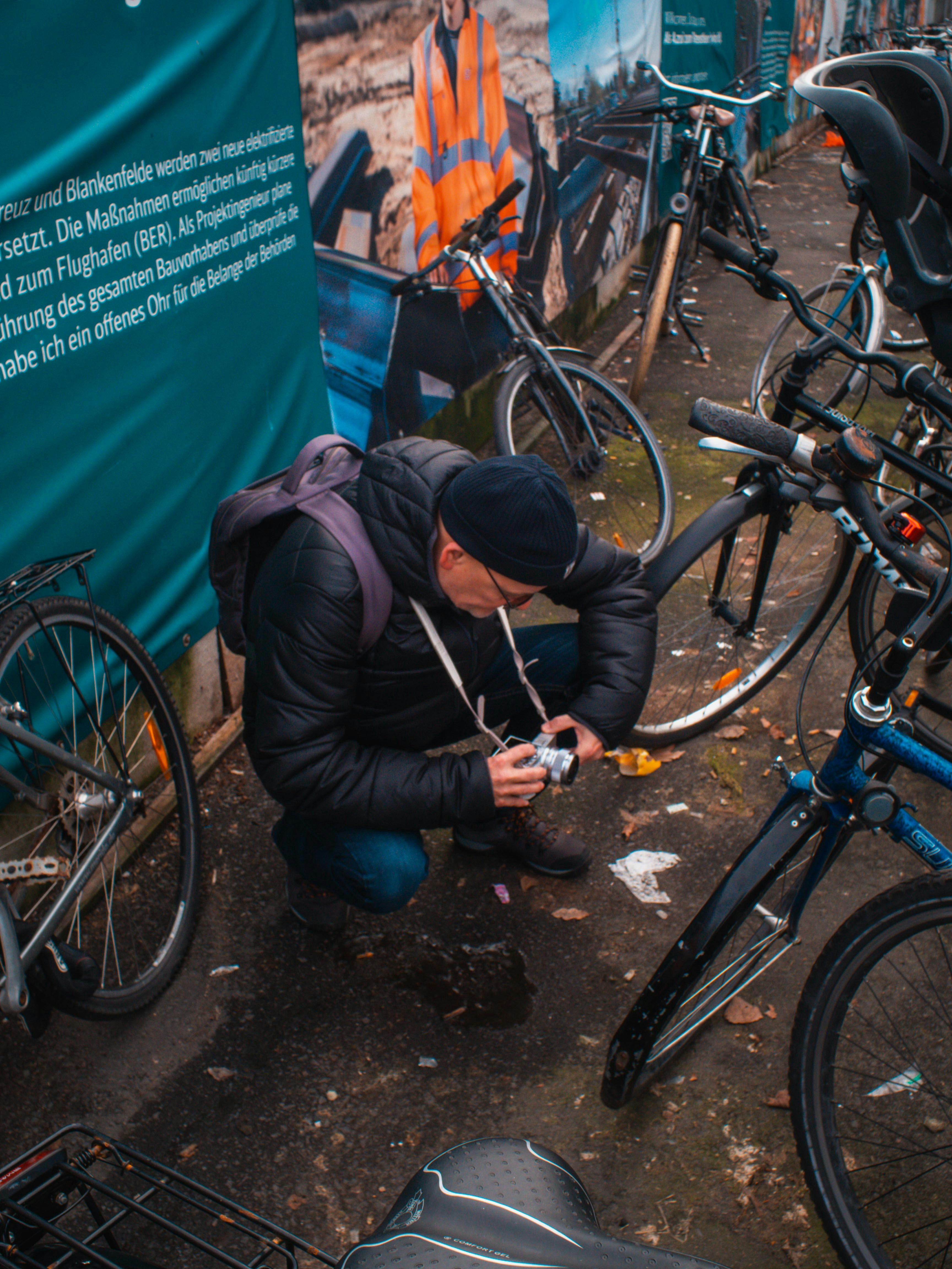 a man kneeling down next to a bunch of bikes