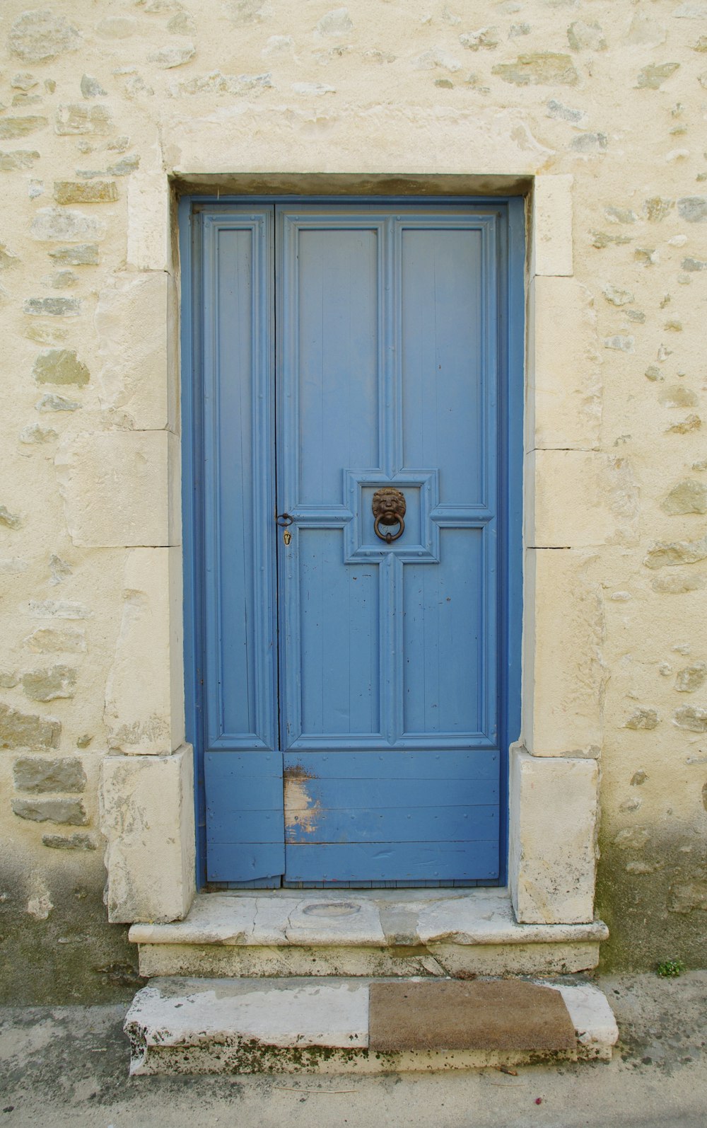 eine blaue Tür an der Seite eines Gebäudes