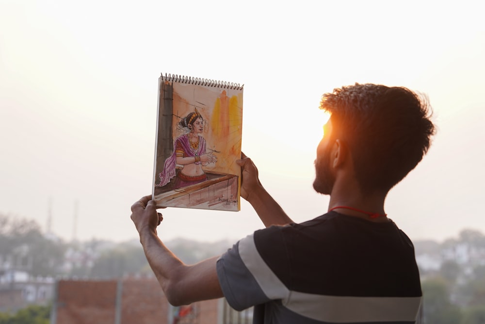 a man holding up a picture of a woman