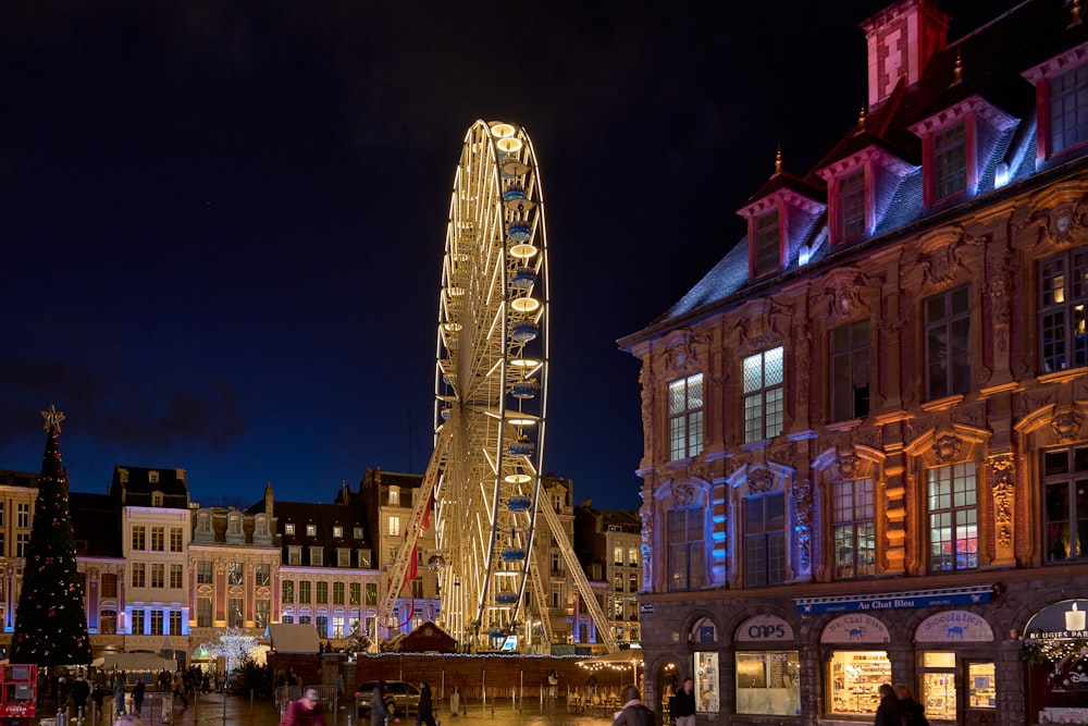 uma roda gigante iluminada à noite em uma cidade