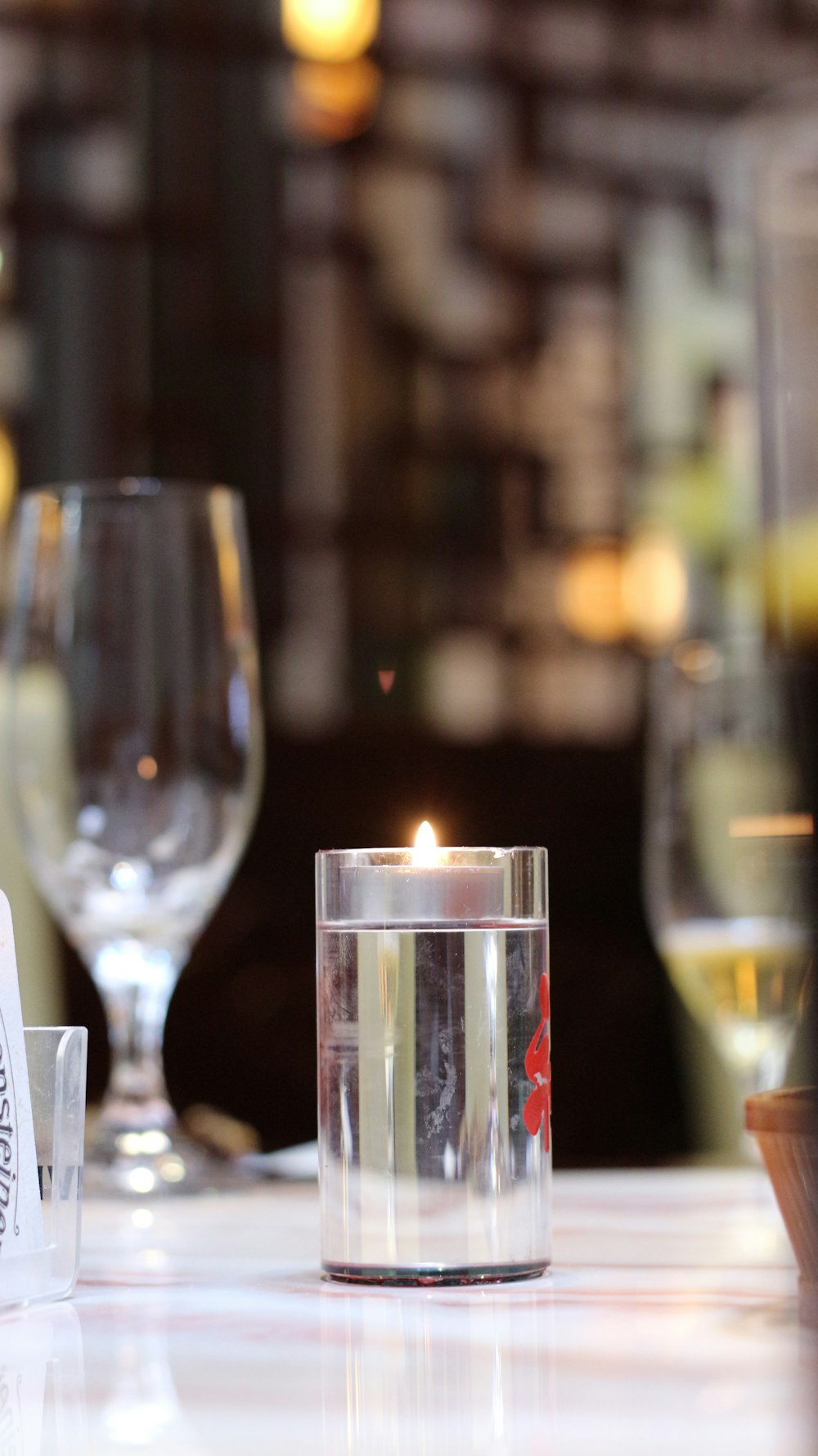 a table with a candle and wine glasses on it
