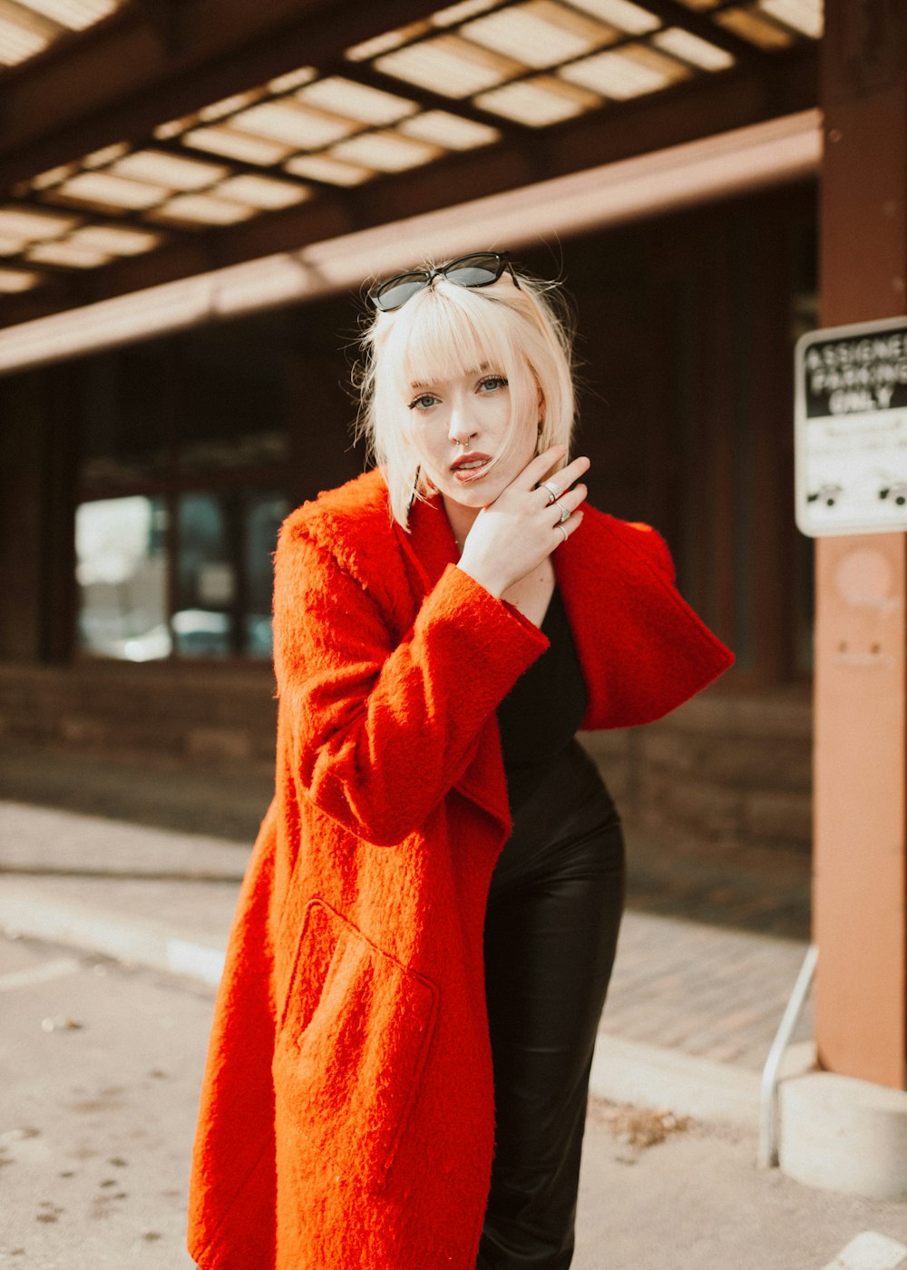 a woman in a red coat is posing for a picture