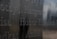 Names are engraved into a reflective metal surface, showing various names in a somber, memorial-like style. The engraving appears deep and is well-crafted, with a muted background reflection.