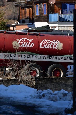 A delivery truck unloading a flexible water tank in a scenic French countryside village.