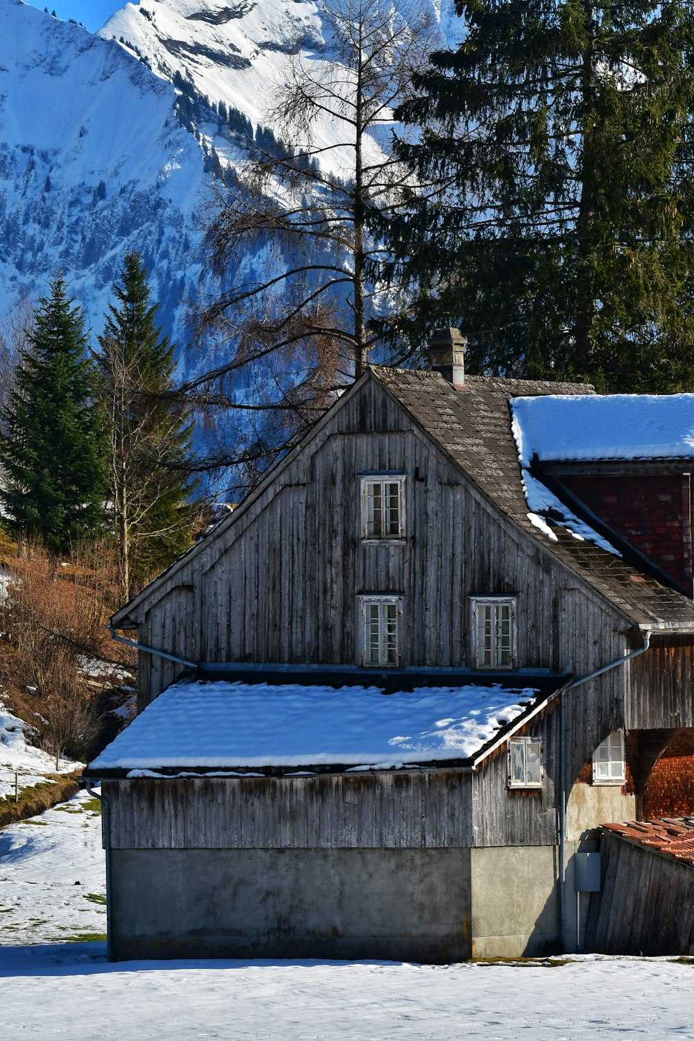 a house with a snow covered mountain in the background