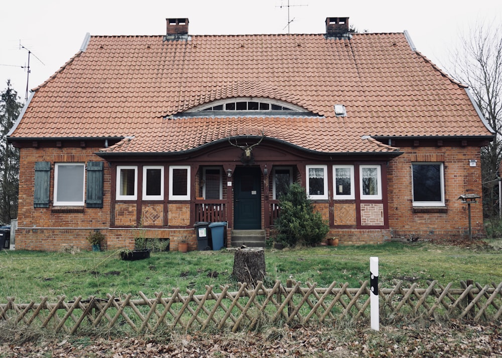 a small brick house with a red roof