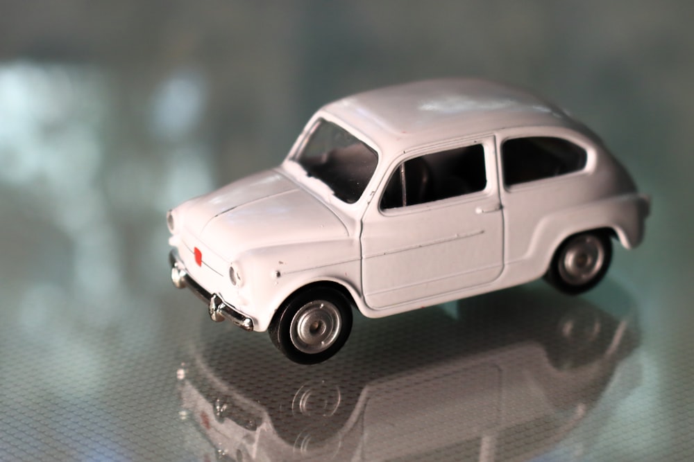 a white toy car sitting on top of a table