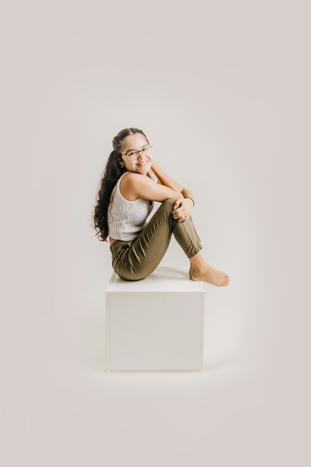 a woman sitting on top of a white box