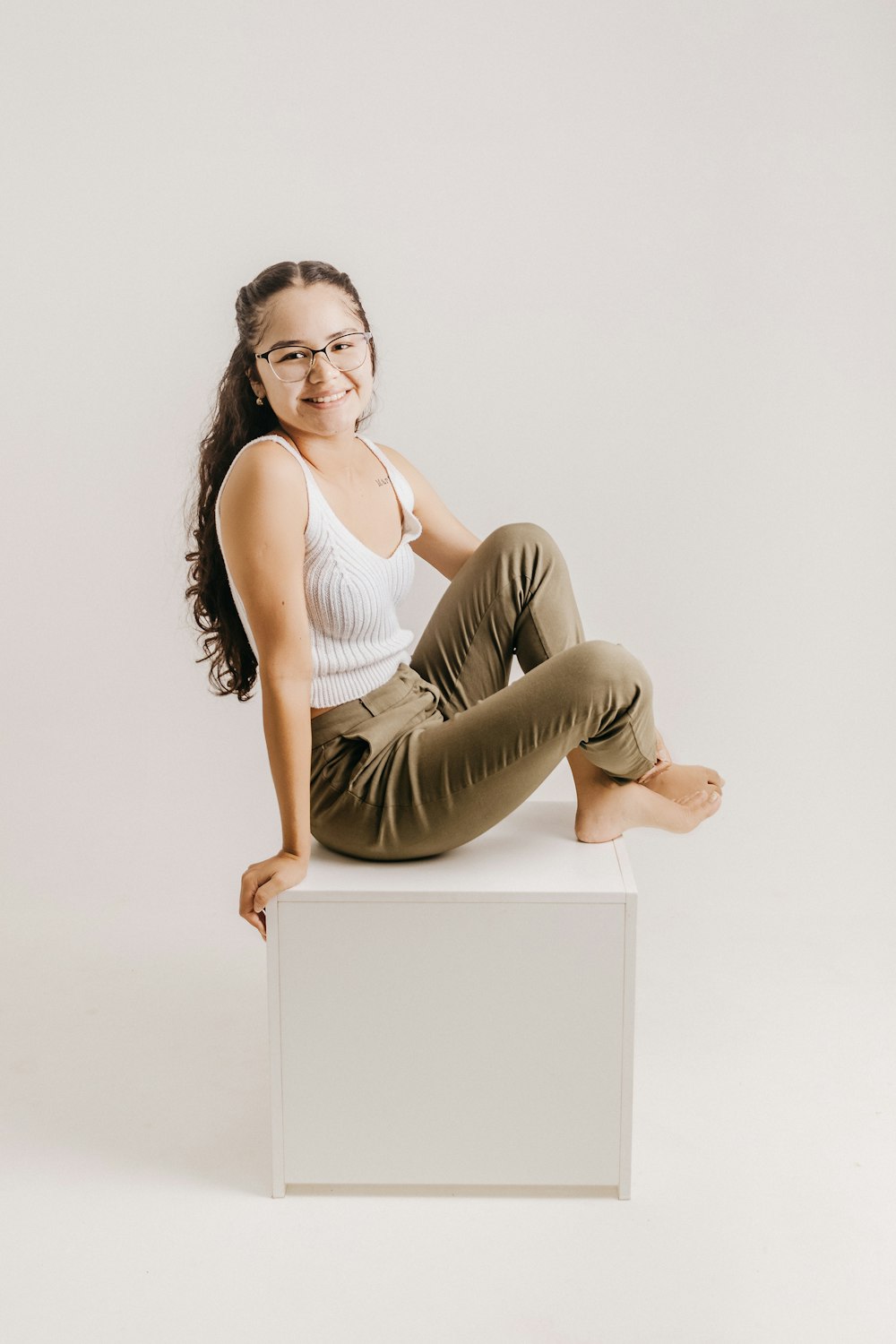 a woman sitting on top of a white box