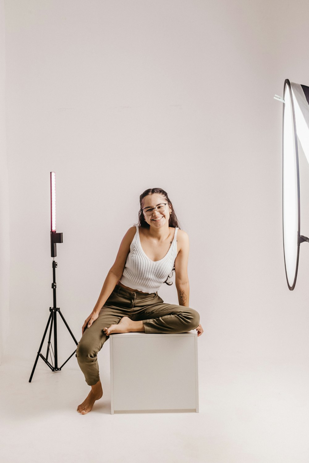 a woman sitting on a stool in front of a camera