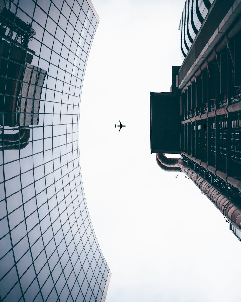 an airplane is flying in the sky between two buildings