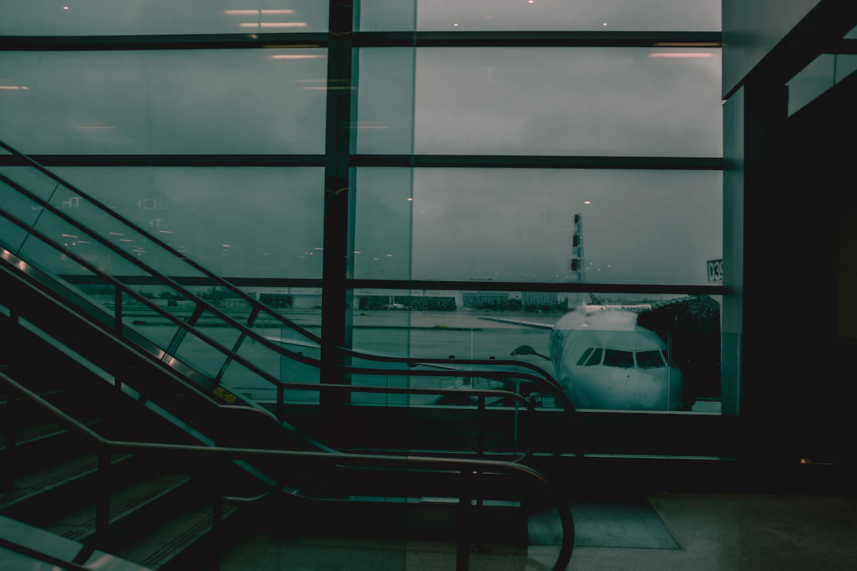 Rain streaming down an airport terminal window with aircraft beyond