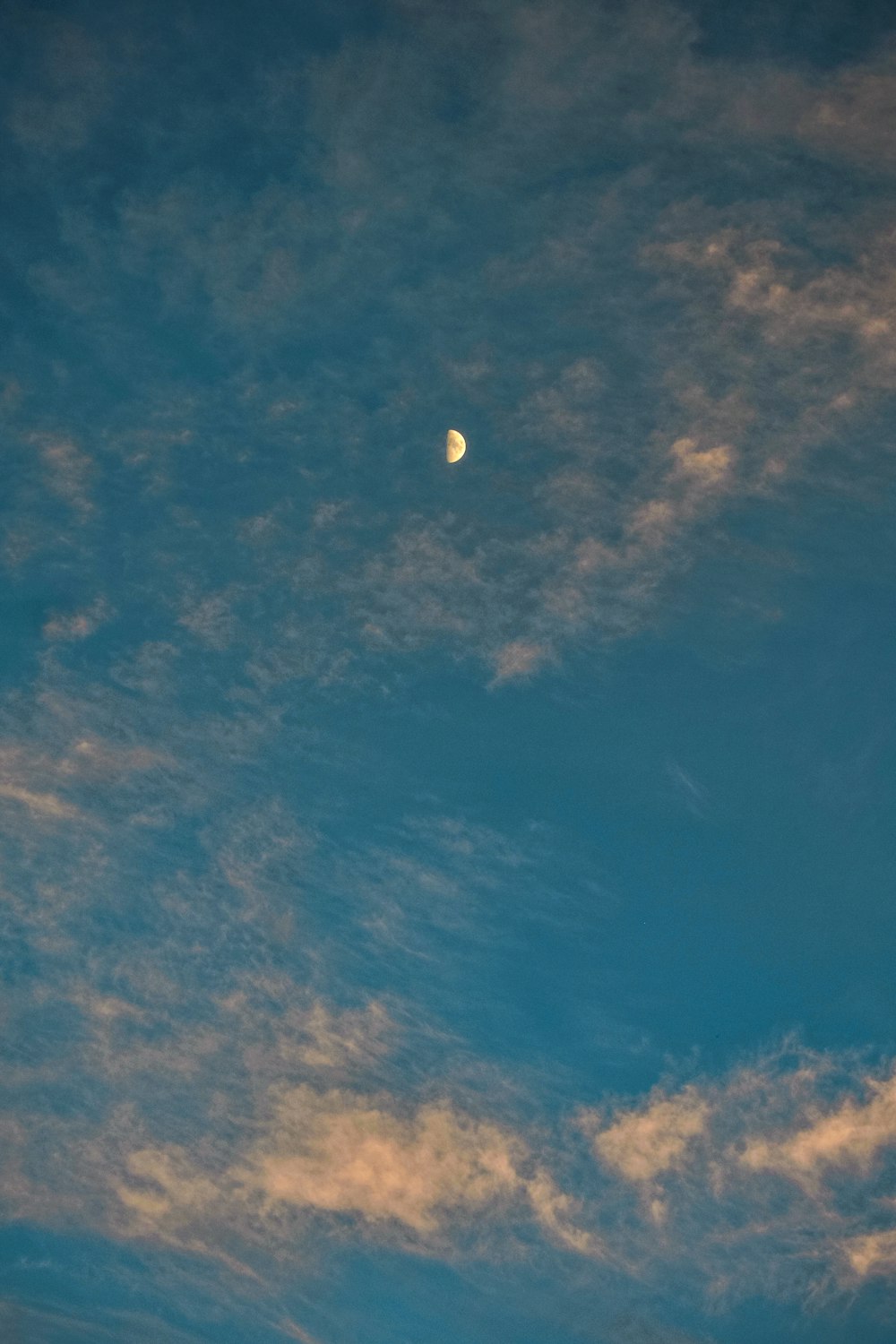 the moon is seen through the clouds in the sky