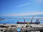 Photo of a maréa cargo ship docked at a bustling port under clear skies.