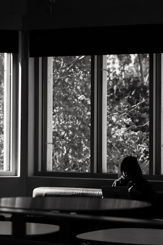A confident person reviewing their monthly budget on a laptop with warm sunlight streaming in.