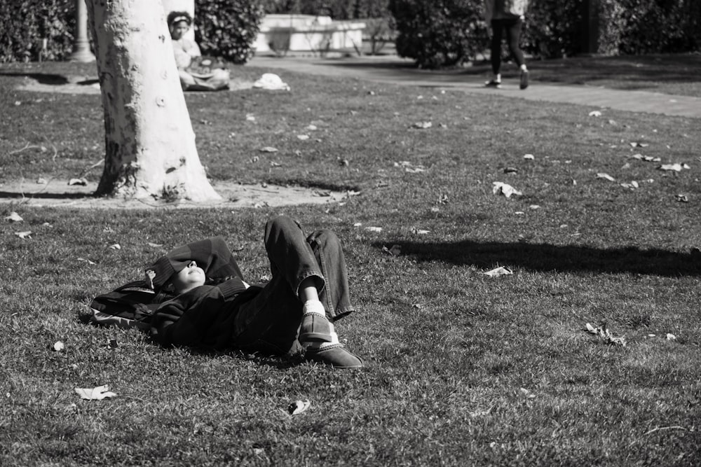 a man laying on the ground in a park