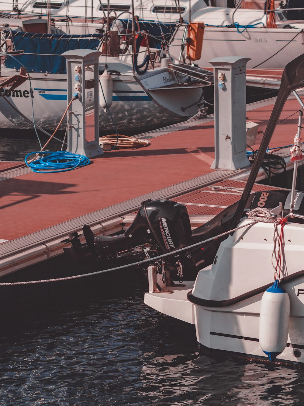 a boat tied to a dock with other boats in the background