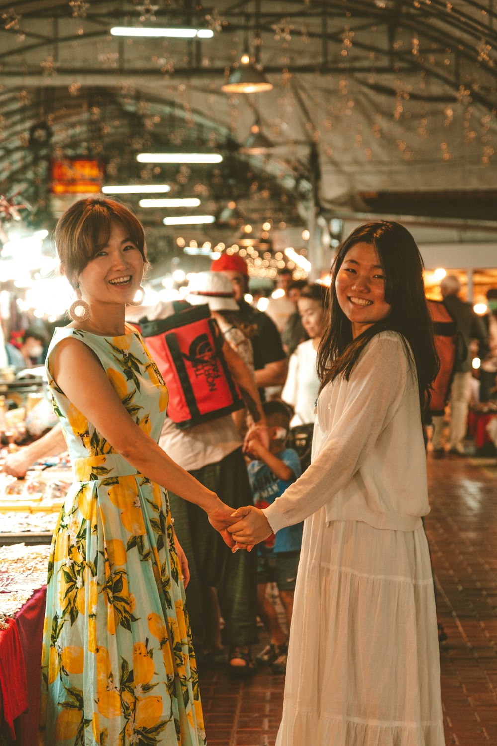 a couple of women standing next to each other holding hands