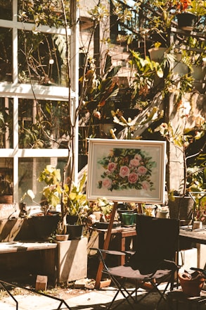 A peaceful garden space with easels set up for a botanical art workshop under soft sunlight.