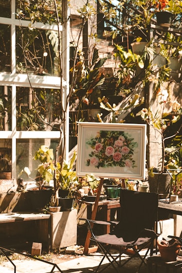 A sunlit garden corner showcasing vibrant plants in handcrafted pots with gardening tools neatly arranged nearby.