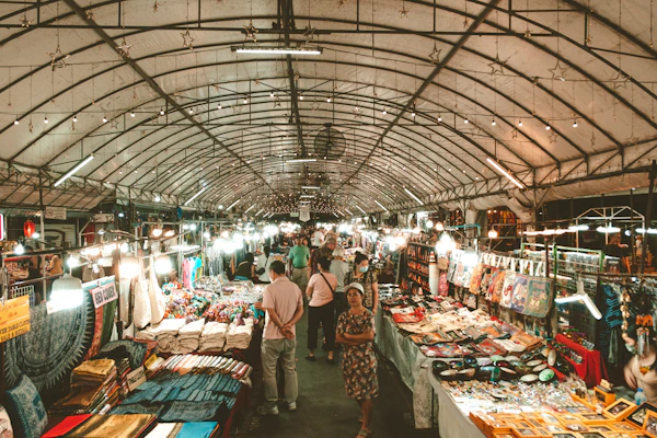 Tourists enjoying the bustling local market in Bukittinggi with colorful stalls and traditional crafts.