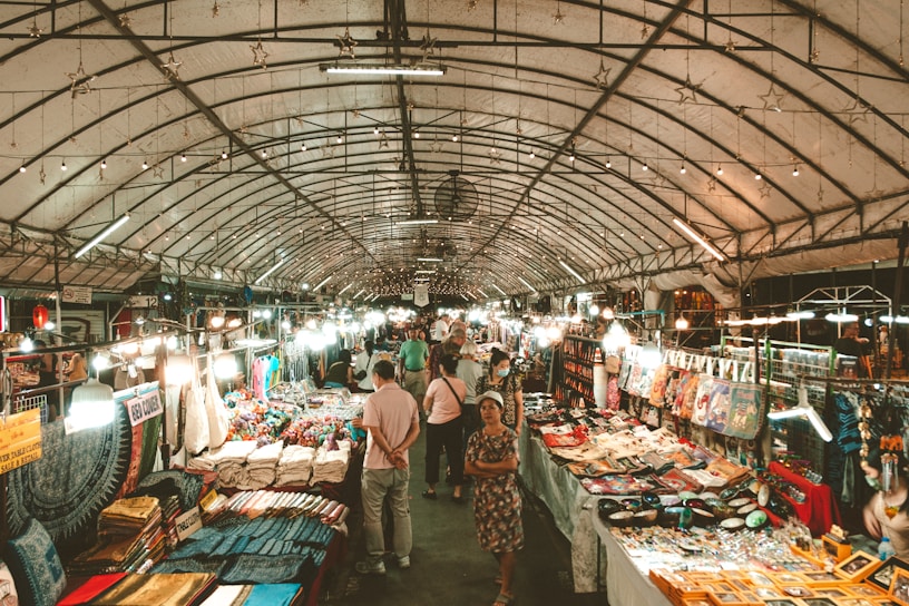 A group of indigenous entrepreneurs from different communities sharing crafts and stories in a vibrant outdoor market.