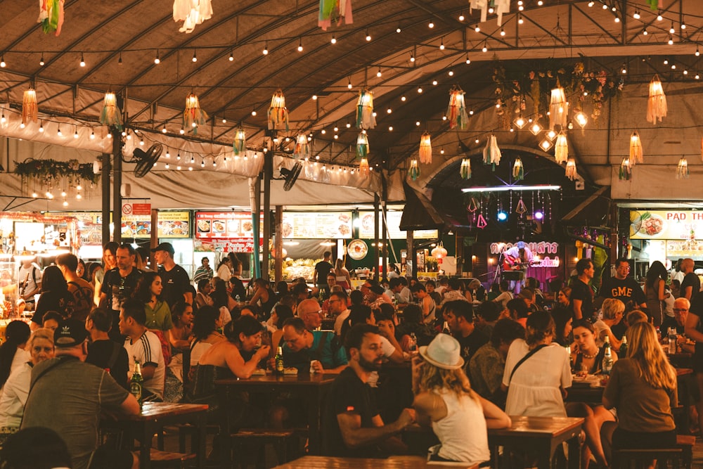 a large group of people sitting at tables in a restaurant