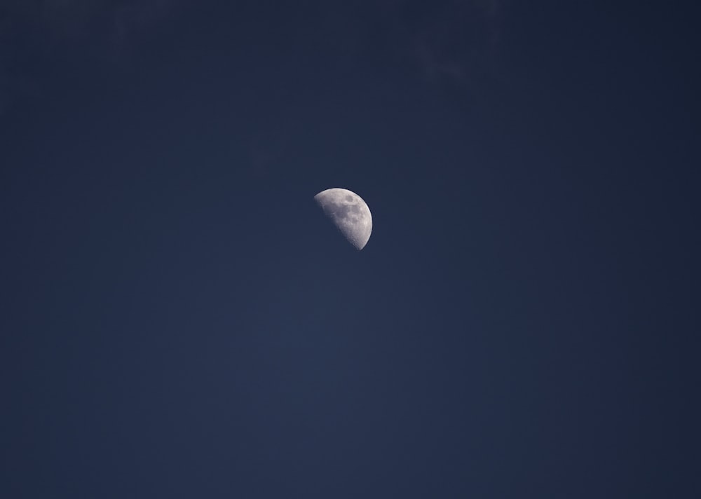 a half moon in a dark blue sky