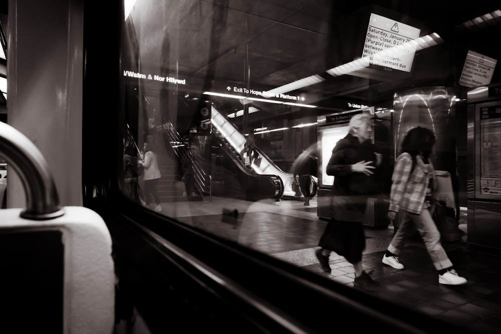 a couple of people that are walking by a train