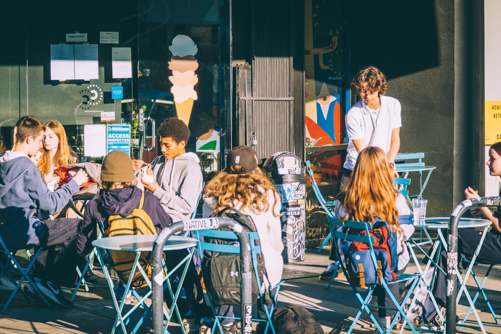 a group of young people sitting around a table