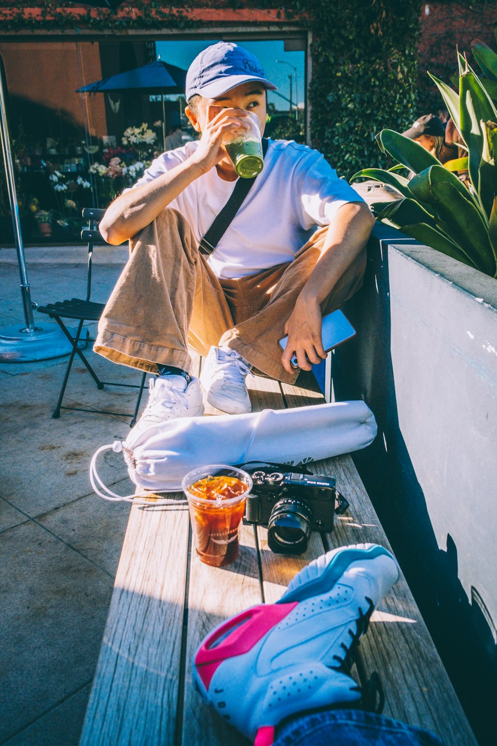 a man sitting on a bench drinking a beverage