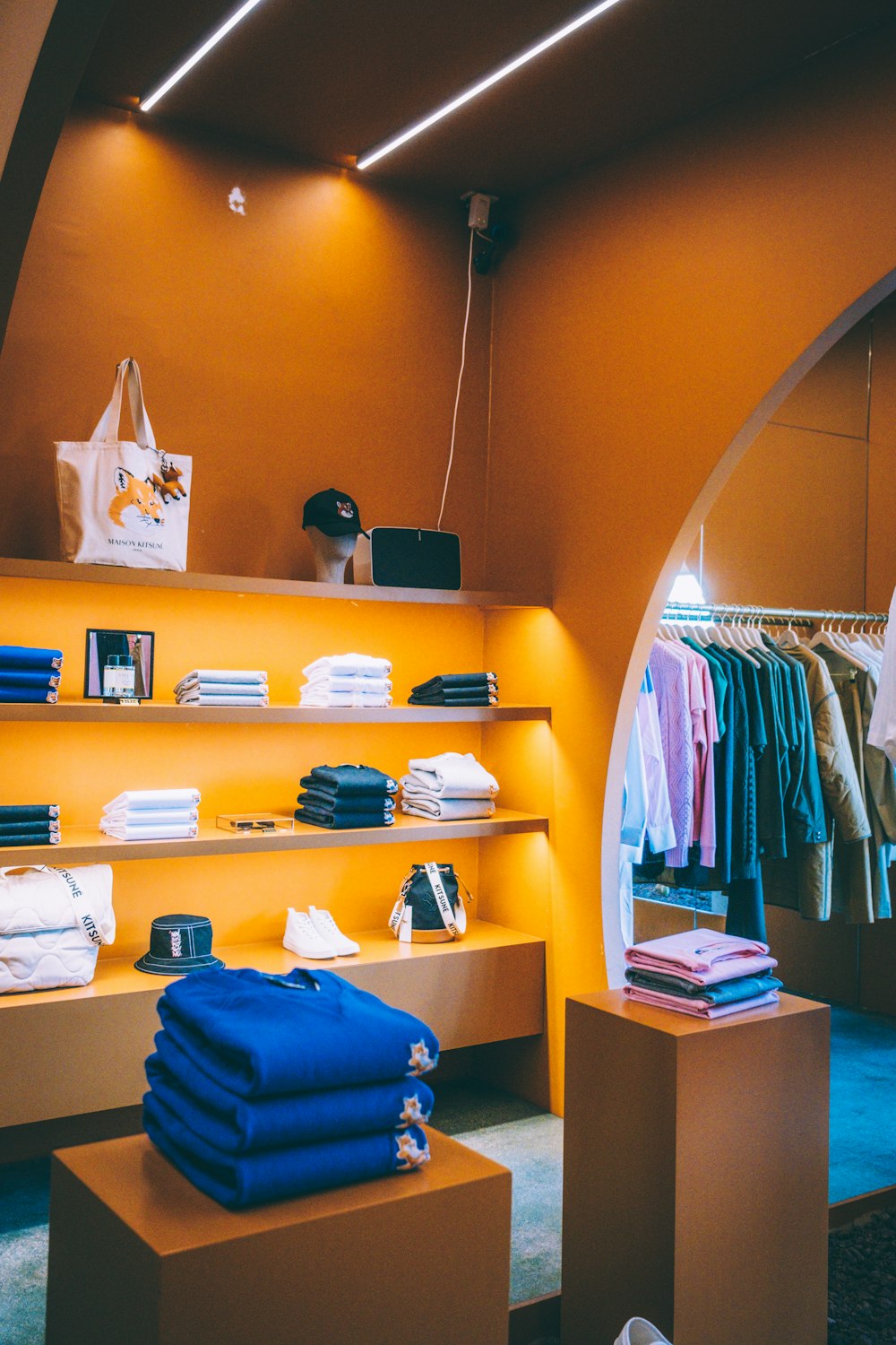 Una tienda de ropa con paredes y estantes naranjas