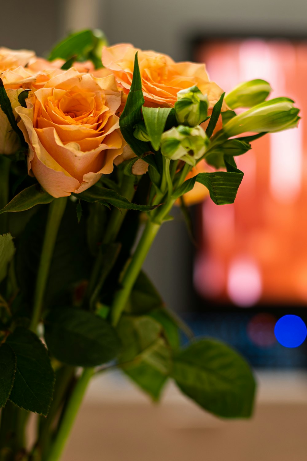 a bouquet of yellow roses in front of a television