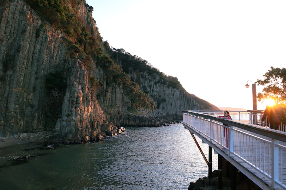 a bridge over a body of water next to a cliff