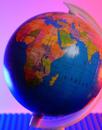 a blue and orange globe with a pink background